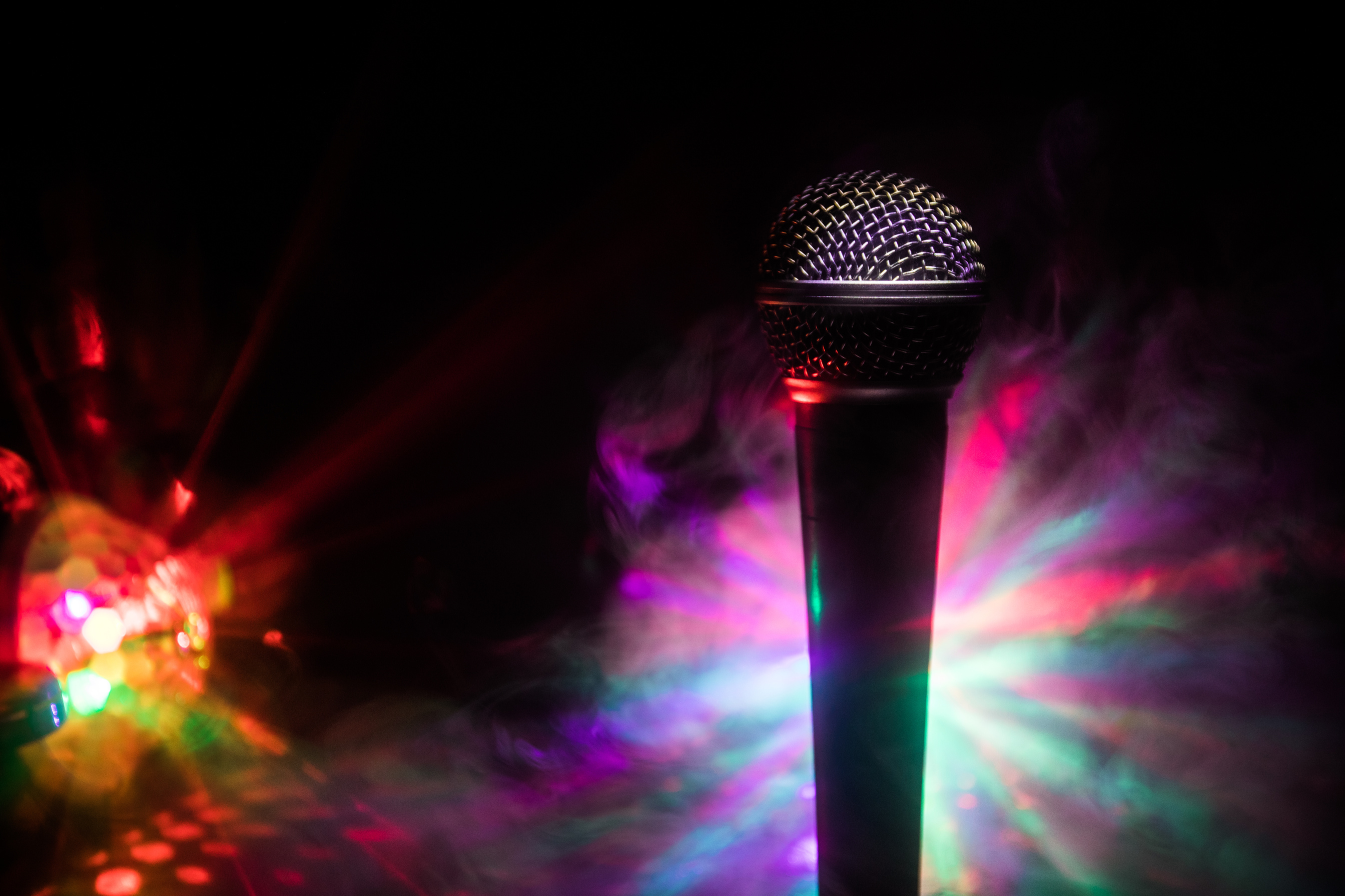 Microphone karaoke, concert . Vocal audio mic in low light with blurred background. Live music, audio equipment. Karaoke concert, sing sound. Singer in karaokes, microphones.