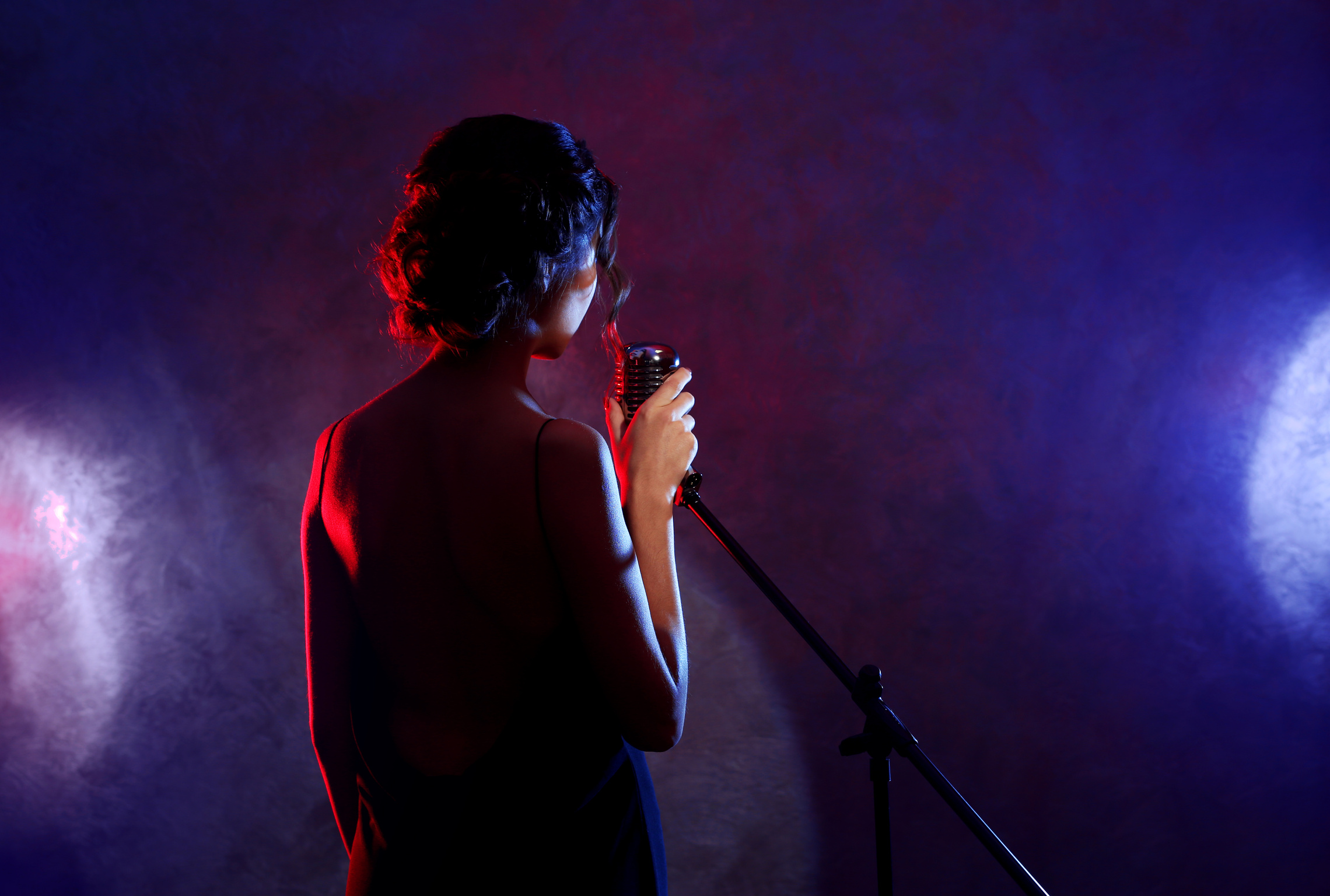 Beautiful Brunette Woman Singing on Purple Background